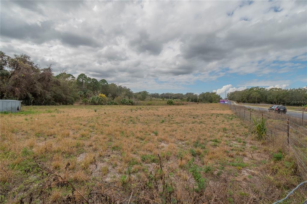 A large, flat, grassy vacant lot sits next to a road under a cloudy sky — 46 A, SANFORD, FL