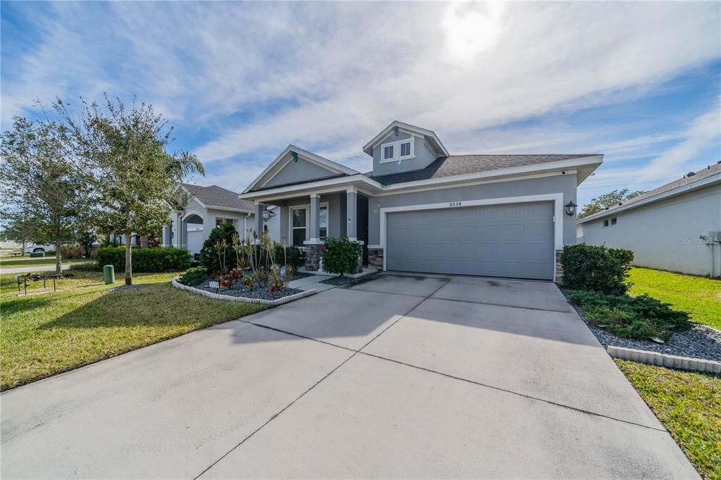 A gray single-story house with a two-car garage and a concrete driveway — 5538 SPANISH MOSS COVE, BRADENTON, FL