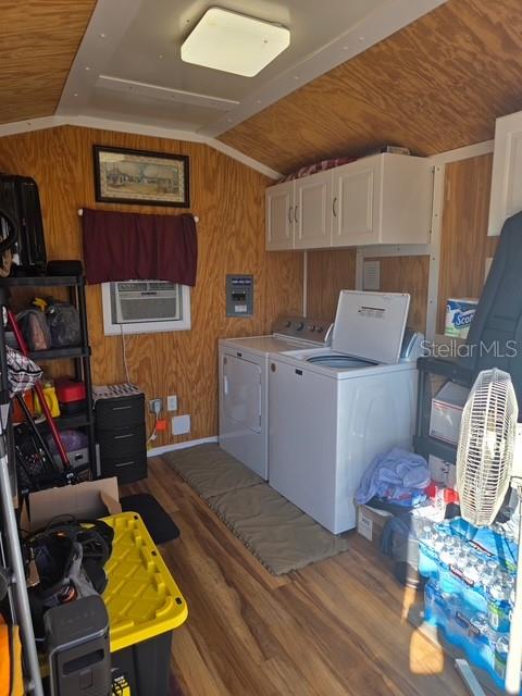 A laundry room with wood-paneled walls, a washer, a dryer, and overhead cabinets — 2537 LEMONWOOD AVENUE, CLERMONT, FL