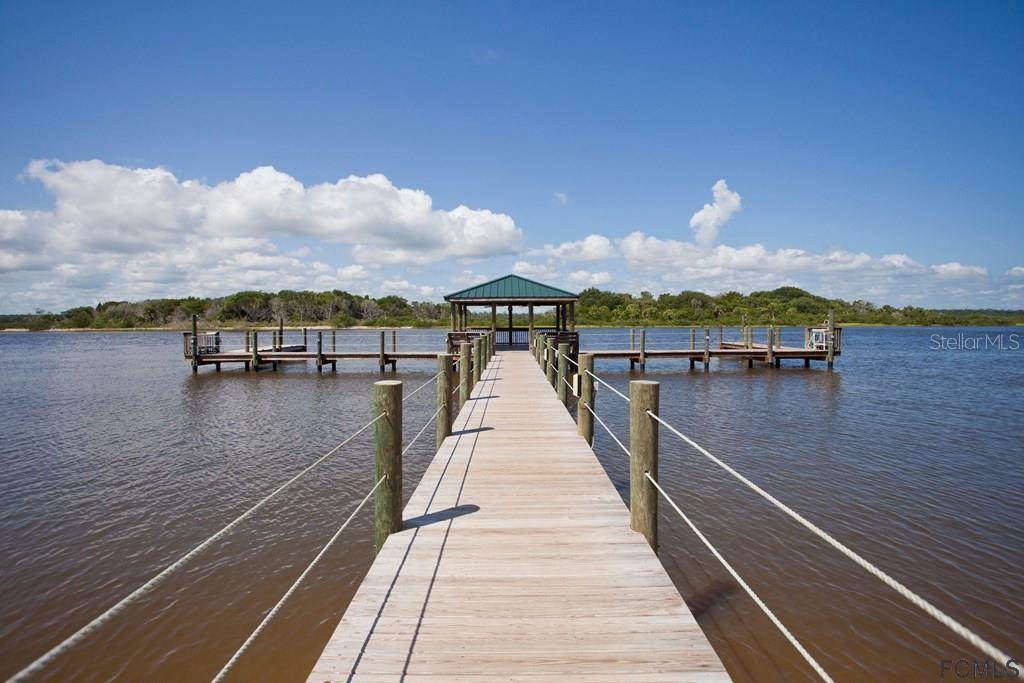 A wooden pier leads to a covered gazebo over a calm body of water — 3 SAN LUIS LANE, PALM COAST, FL