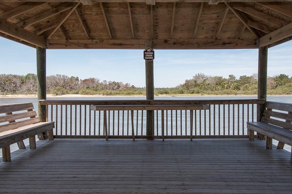 A wooden gazebo overlooks a body of water with benches on both sides — 3 SAN LUIS LANE, PALM COAST, FL