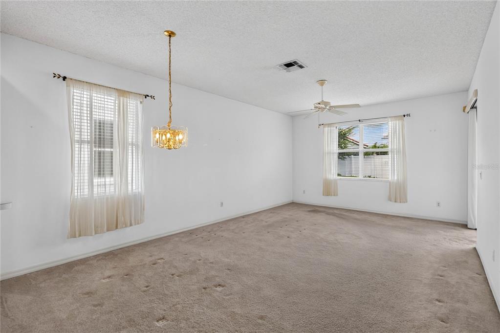 An empty room with beige carpeting, white walls, a ceiling fan, and a hanging chandelier — 923 TORREY PINE DRIVE, WINTER SPRINGS, FL
