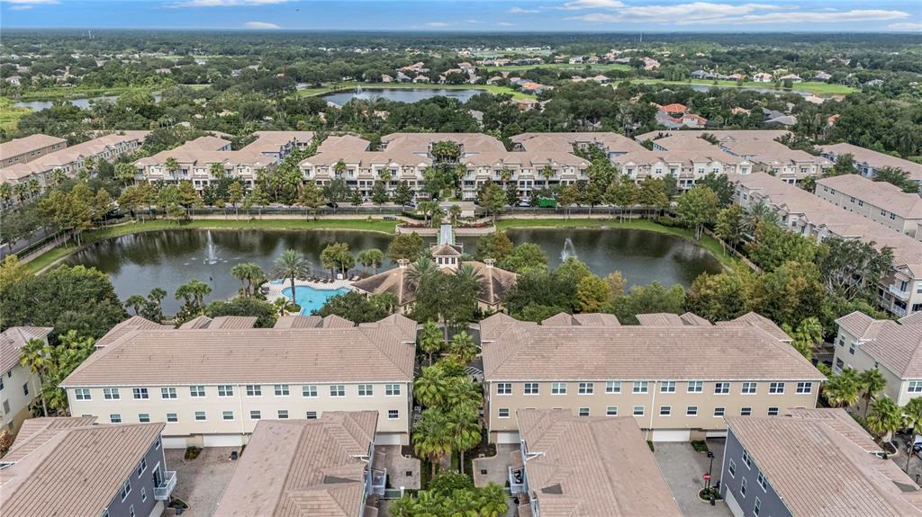 The exterior of a multi-story townhouse complex features white railings, green doors, and balconies — 1483 LAKE GEORGE DRIVE, LAKE MARY, FL