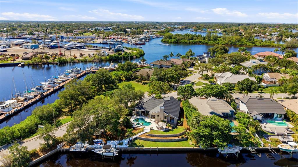 An aerial view shows a waterfront house with a pool and boat dock near a marina — 1102 MARINA DRIVE, TARPON SPRINGS, FL