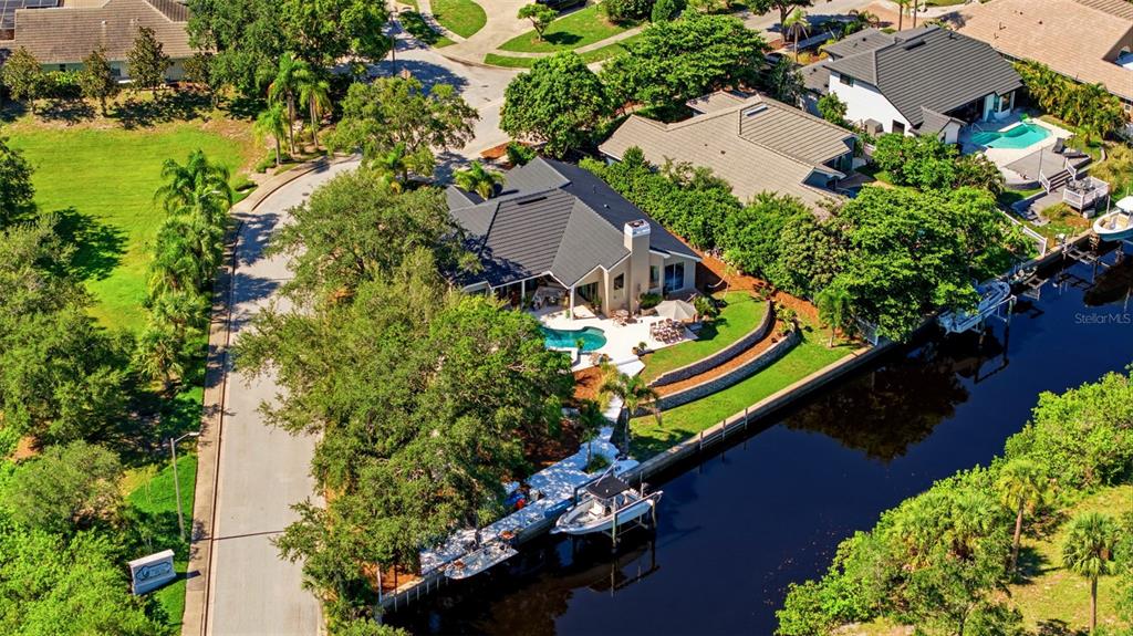 An aerial view shows a house with a pool, boat dock, and canal access — 1102 MARINA DRIVE, TARPON SPRINGS, FL
