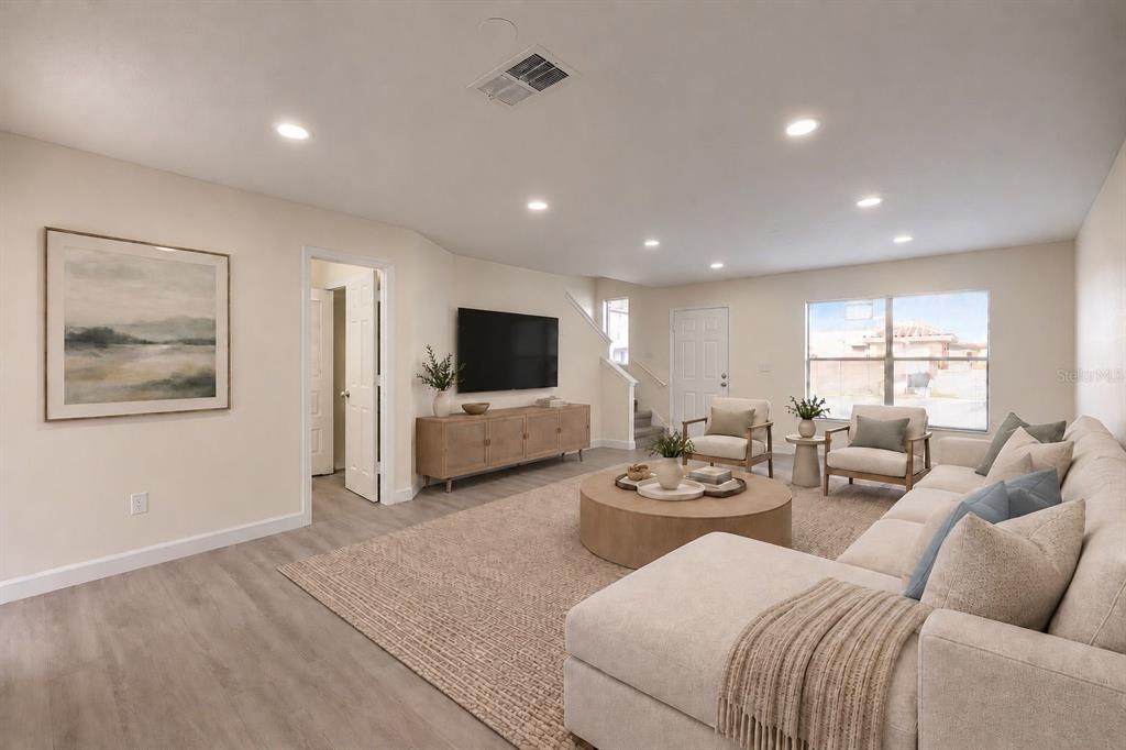 A modern living room features light wood flooring, a large sectional sofa, and recessed lighting — 6266 YORKTOWN DRIVE UNIT 179, ORLANDO, FL