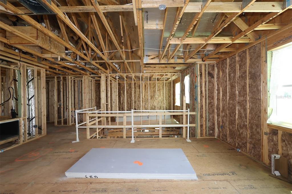 An unfinished room under construction with exposed wooden framing, insulation, and a sheet of drywall — 2873 SWEETGRASS LANE, ZELLWOOD, FL