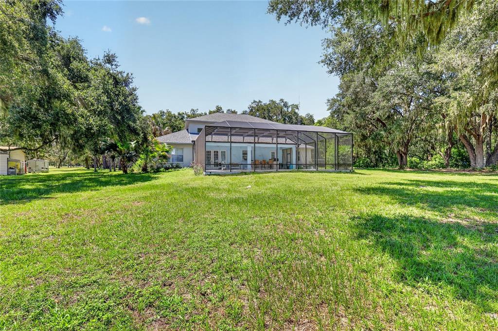 A two-story stucco house with a gray shingled roof and teal double front doors — 10639 SE SUNSET HARBOR ROAD, SUMMERFIELD, FL