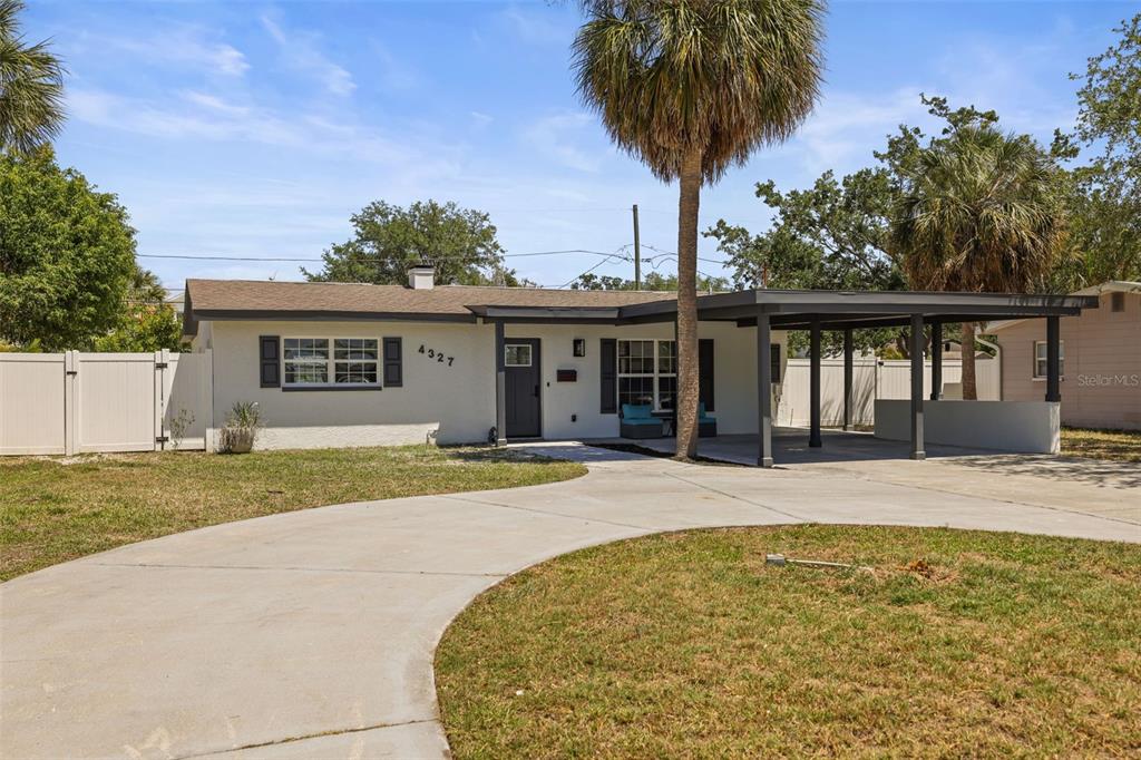 A single-story house with a white exterior, a carport, and a curved concrete driveway — 4327 HUNTINGTON STREET NE, ST PETERSBURG, FL