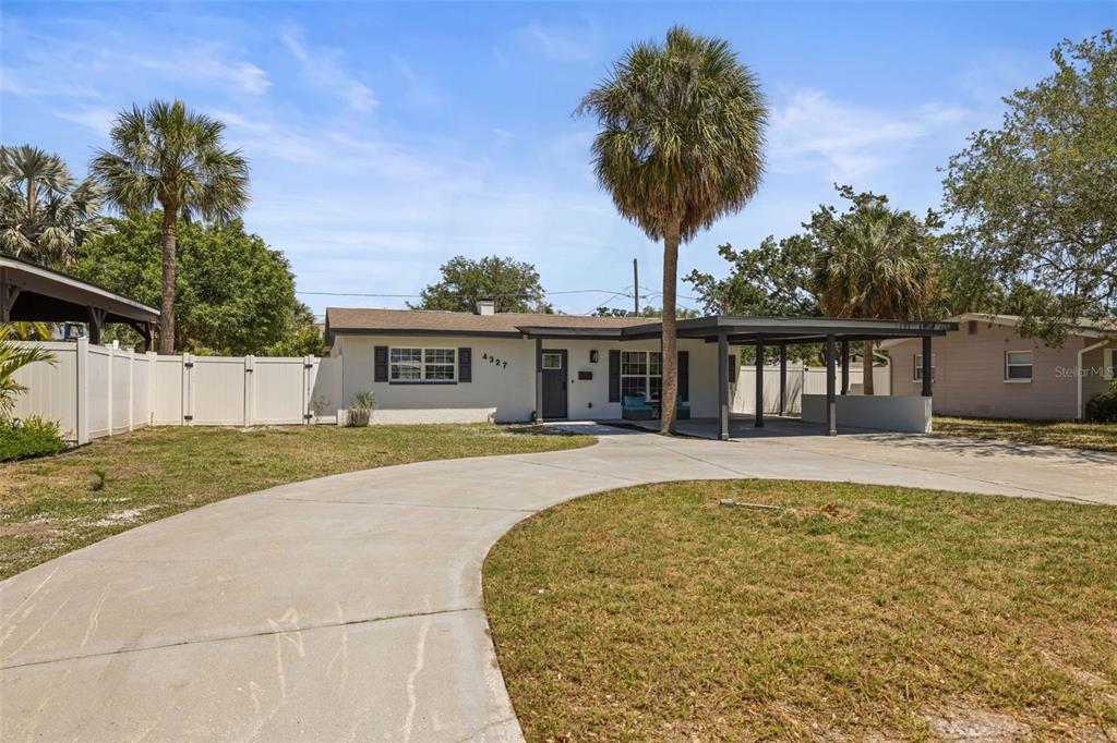 A single-story house with a white exterior, a carport, and a curved concrete driveway — 4327 HUNTINGTON STREET NE, ST PETERSBURG, FL
