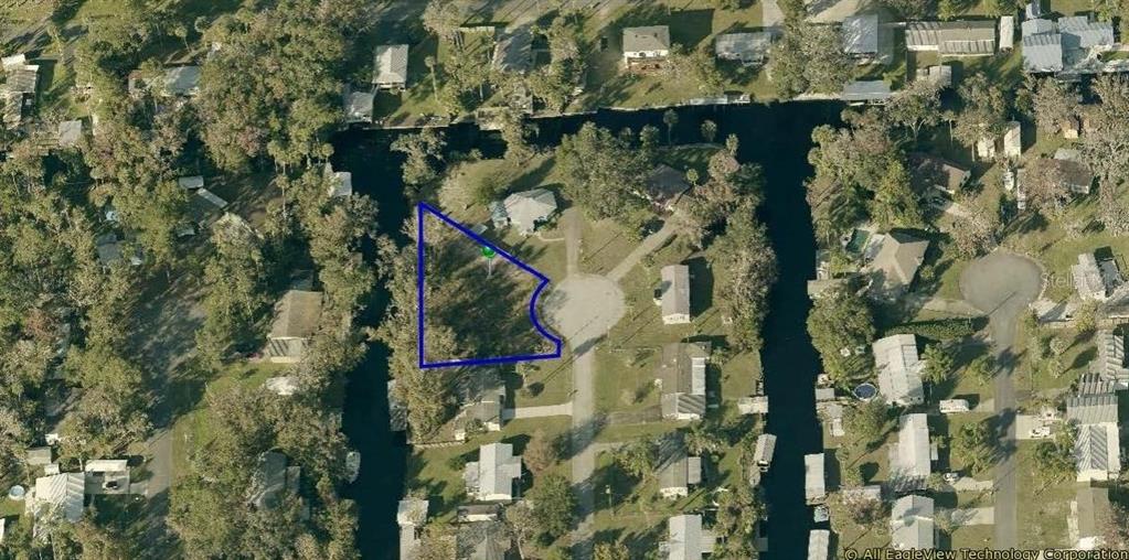This aerial map shows a vacant, irregularly shaped residential lot outlined in blue — 55813 SAM STREET, ASTOR, FL