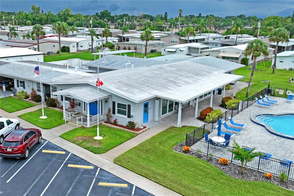 An aerial view shows a community clubhouse with a pool, parking lot, and surrounding homes — 2000 E BAY DRIVE UNIT 25, LARGO, FL