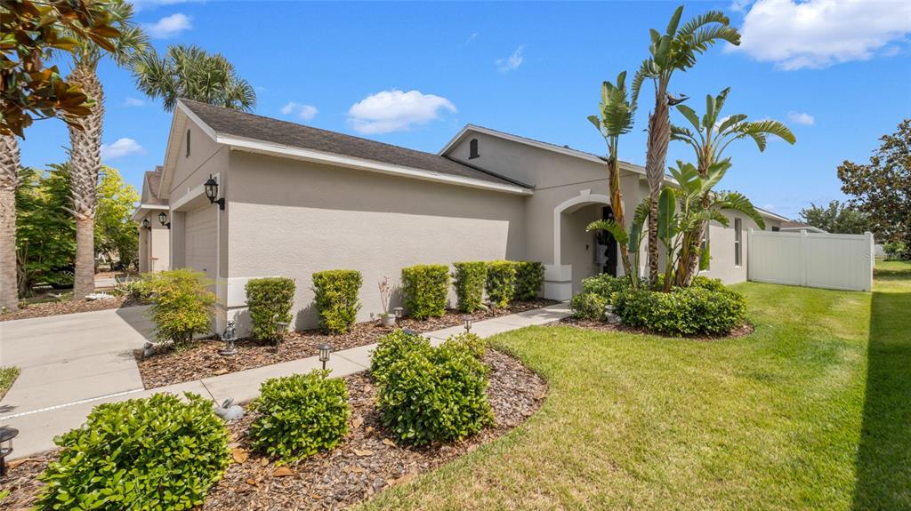 A single-story house with a beige exterior, a concrete driveway, and landscaped front yard — 7120 FOREST MERE DRIVE, RIVERVIEW, FL