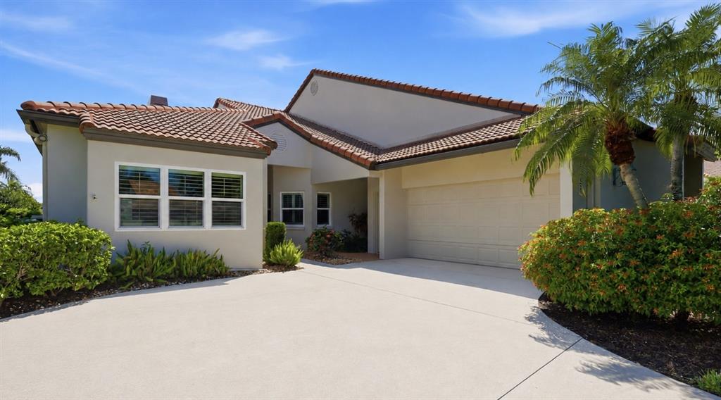 A single-story house with a tiled roof, a two-car garage, and a concrete driveway — 7765 CALLE FACIL, SARASOTA, FL