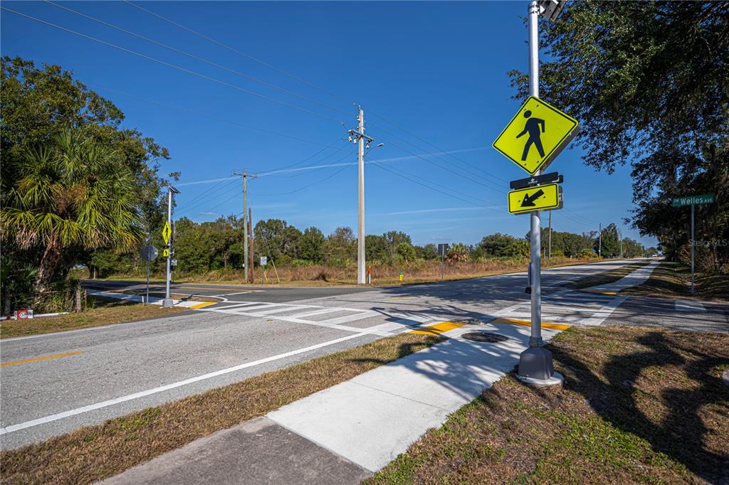 A pedestrian crossing with a crosswalk sign and street sign at a paved intersection — SW CO RD 760A, ARCADIA, FL