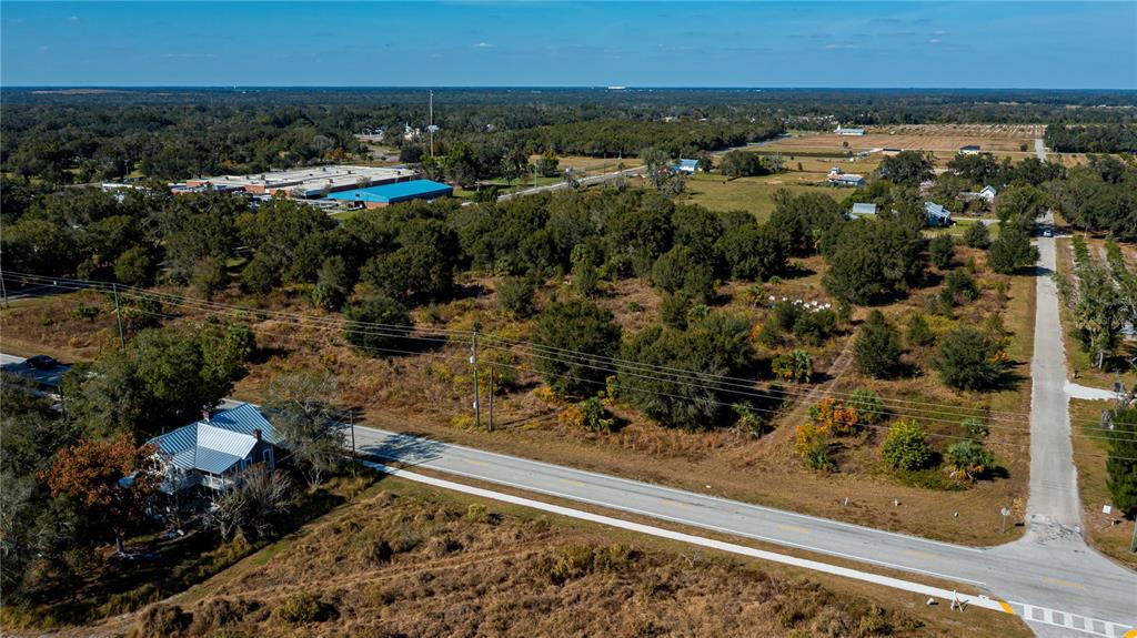 An aerial view shows a two-story house beside a road and a large wooded lot — SW CO RD 760A, ARCADIA, FL