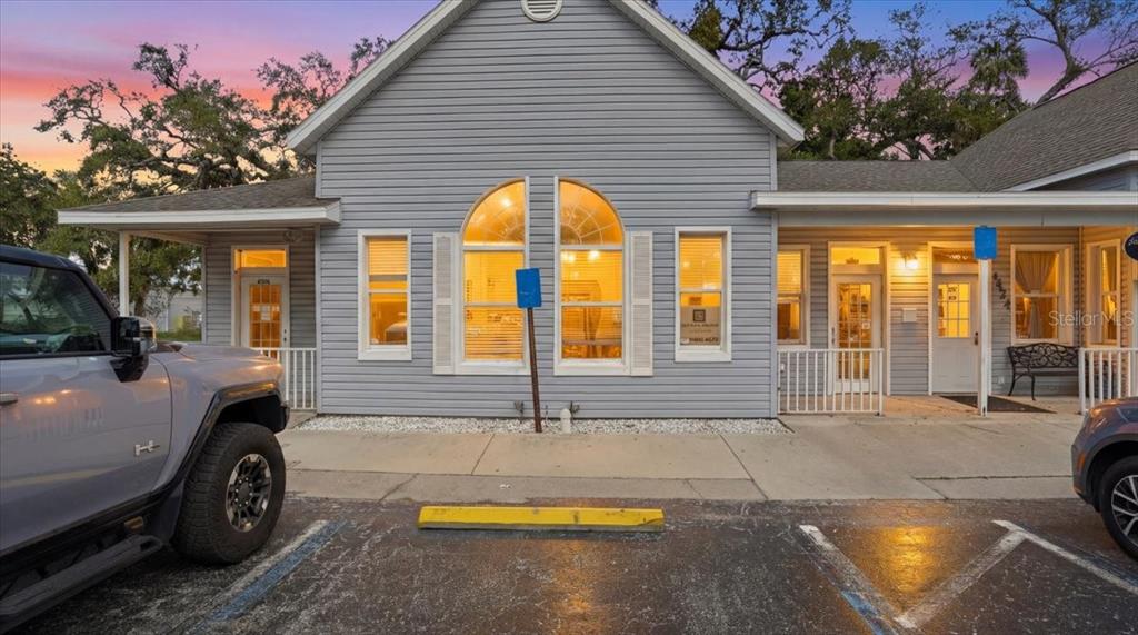 A gray-sided commercial building with arched windows and a parking lot in the foreground — 4426 5TH STREET W, BRADENTON, FL