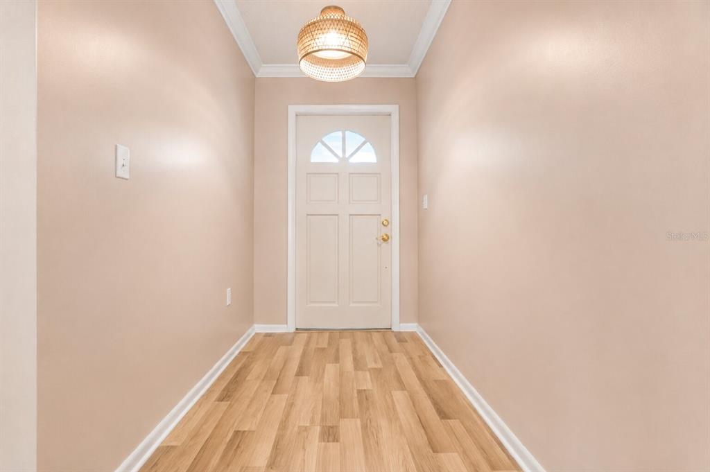 A white single-story house features a landscaped front yard with a large bush and trees — 510 PALMER CIRCLE, PALM HARBOR, FL