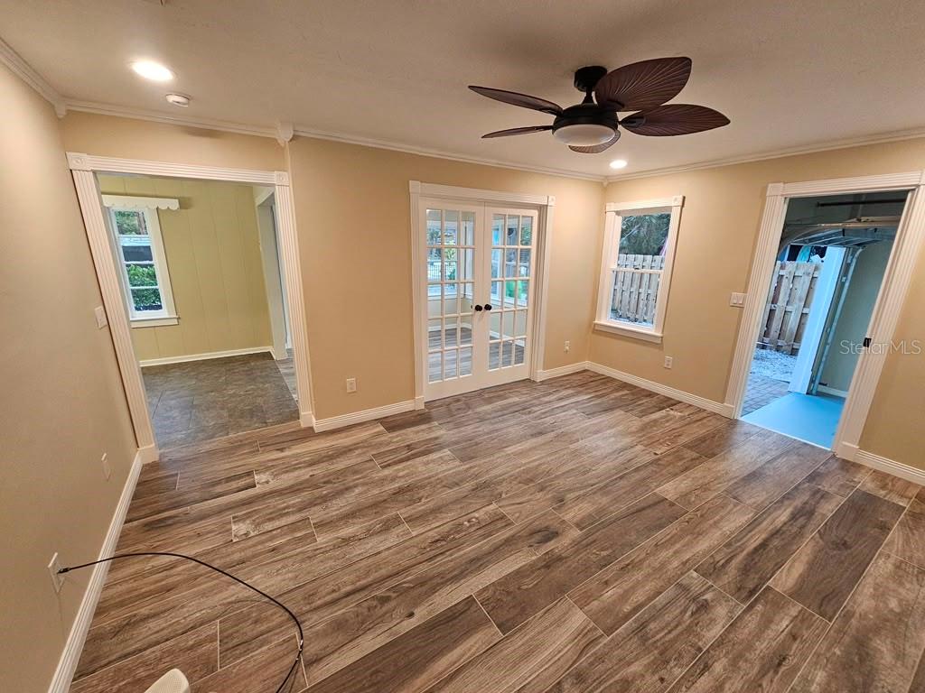 A green house with a red metal roof, white trim, and a brick paver driveway — 1277 17TH STREET, SARASOTA, FL