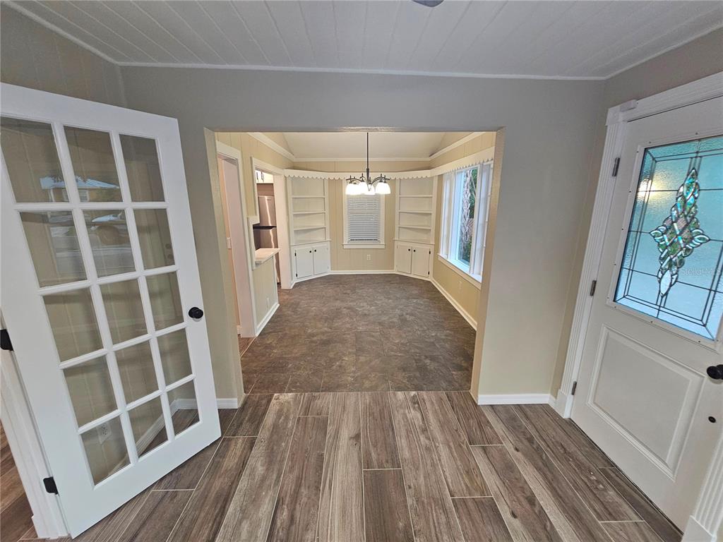 A white front door with a decorative glass insert sits under a striped green awning — 1277 17TH STREET, SARASOTA, FL