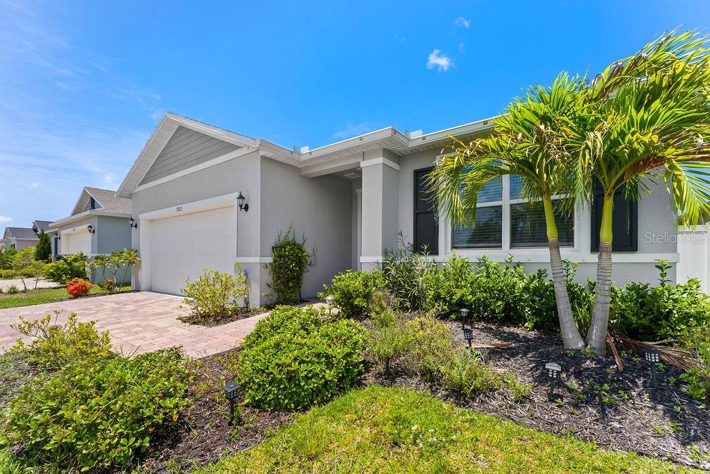A single-story house with a gray stucco exterior, a two-car garage, and a palm tree — 7322 34TH COURT E, SARASOTA, FL