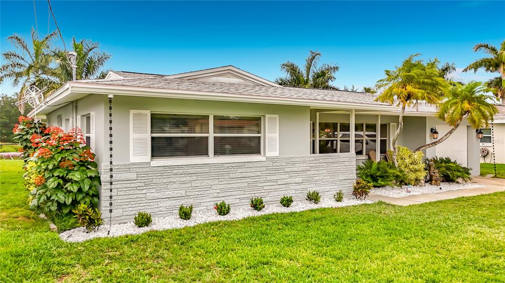 A single-story house with light gray siding, a stone facade, and a landscaped front yard — 508 SHORE DRIVE, LARGO, FL