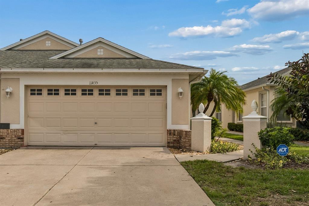 A tan single-story house with a two-car garage and a concrete driveway — 11435 CAMBRAY CREEK LOOP, RIVERVIEW, FL