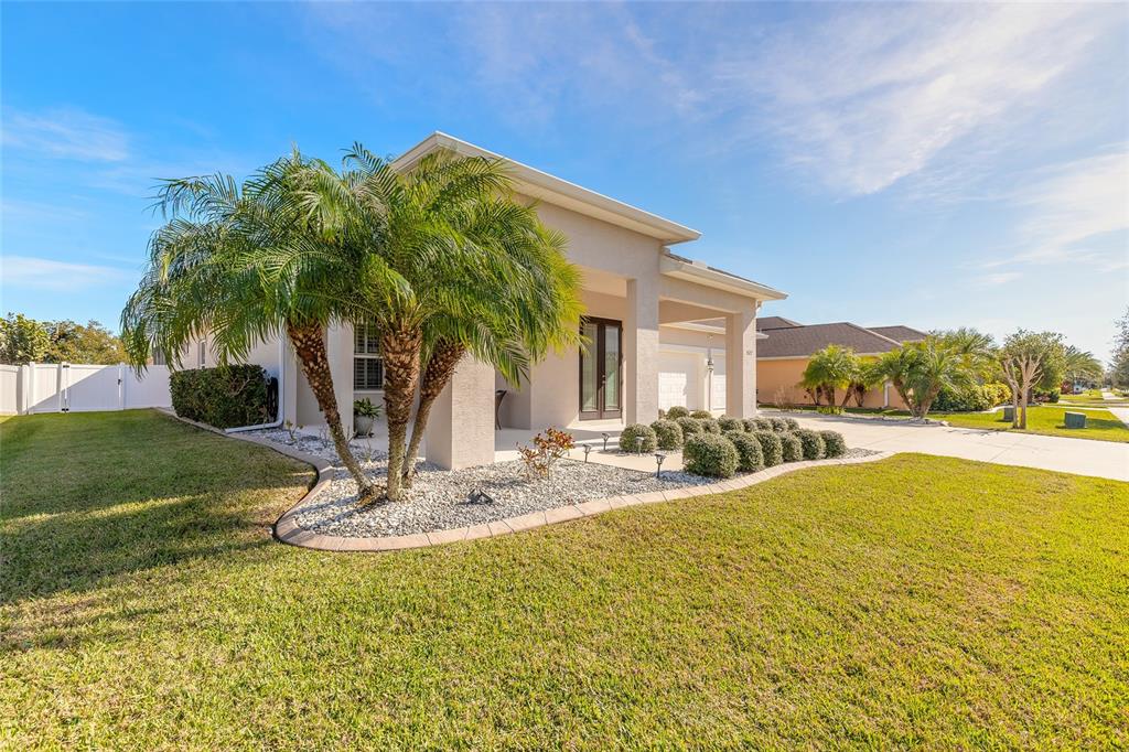A single-story house with a palm tree, stone landscaping, and a paved driveway — 527 LUNA BELLA LANE, NEW SMYRNA BEACH, FL