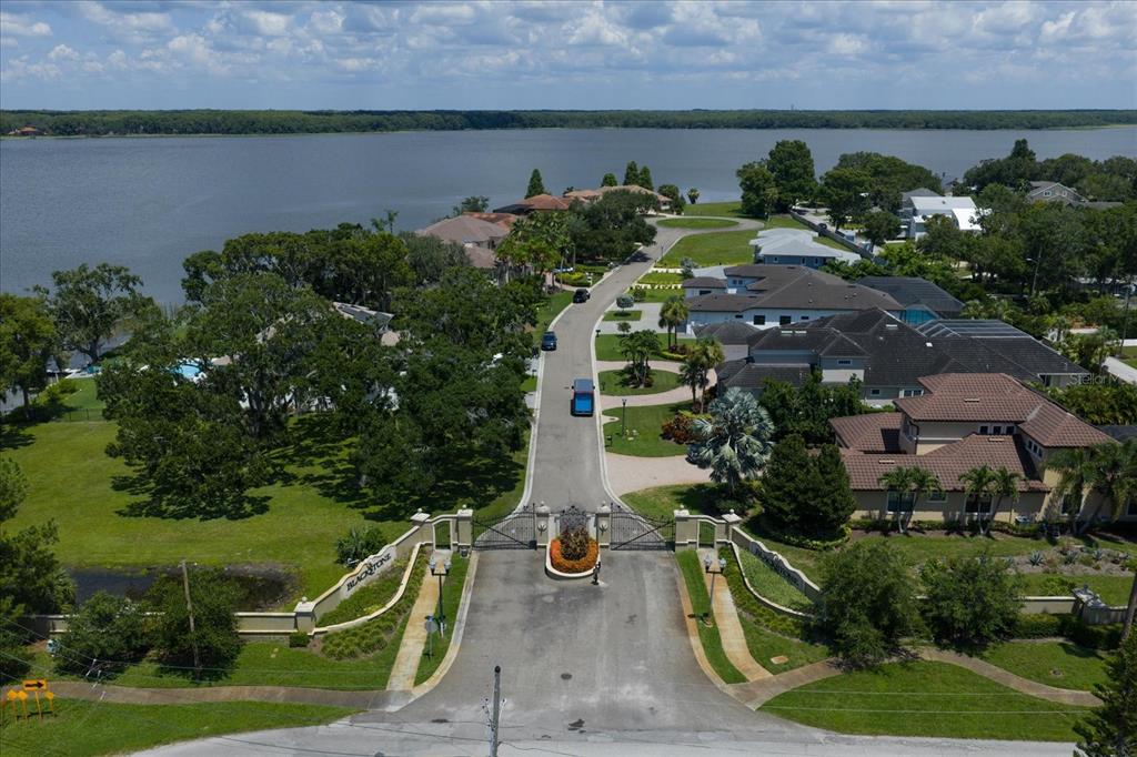 An aerial view shows the gated entrance to a residential community situated along a lake — 0 BLACKSTONE DRIVE, PALM HARBOR, FL