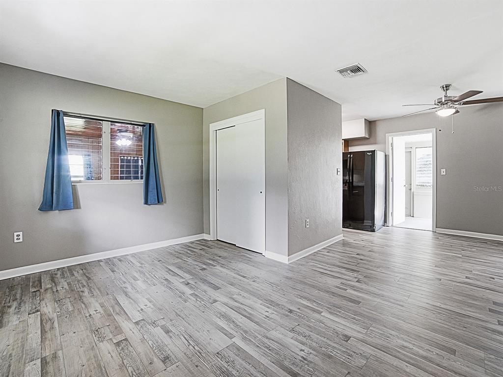 A room with gray walls, wood-look flooring, a sliding closet door, and a ceiling fan — 2014 HELMS AVENUE, LEESBURG, FL