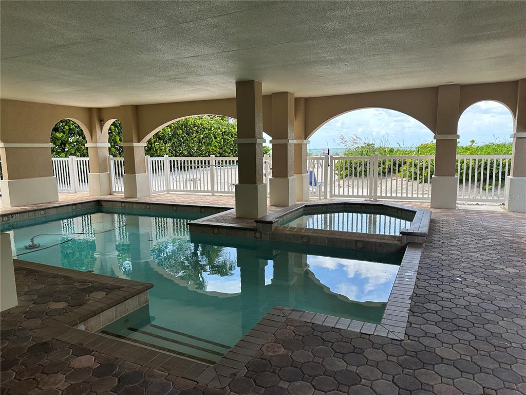 A three-story house with a paved driveway, three garage doors, and two upper-level balconies — 106 74TH STREET UNIT 100, HOLMES BEACH, FL