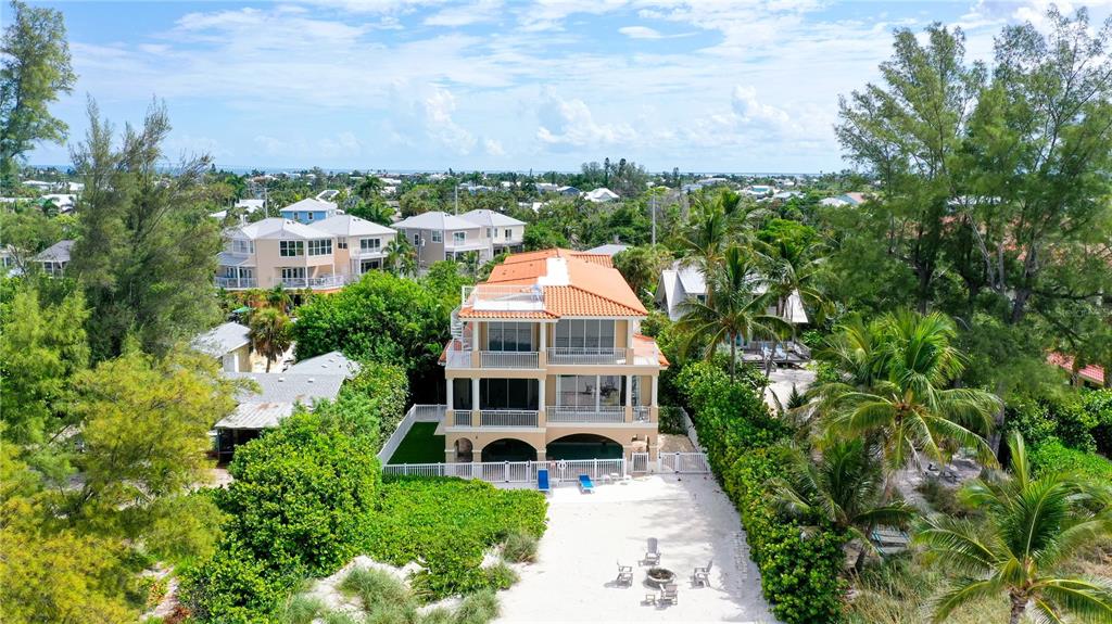 A covered patio features a swimming pool and hot tub overlooking a sunset beach view — 106 74TH STREET UNIT 100, HOLMES BEACH, FL