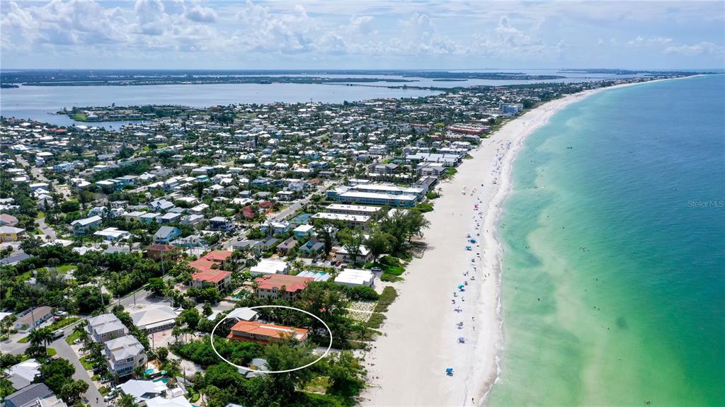 A covered patio features a swimming pool, a hot tub, and beige columns — 106 74TH STREET UNIT 100, HOLMES BEACH, FL