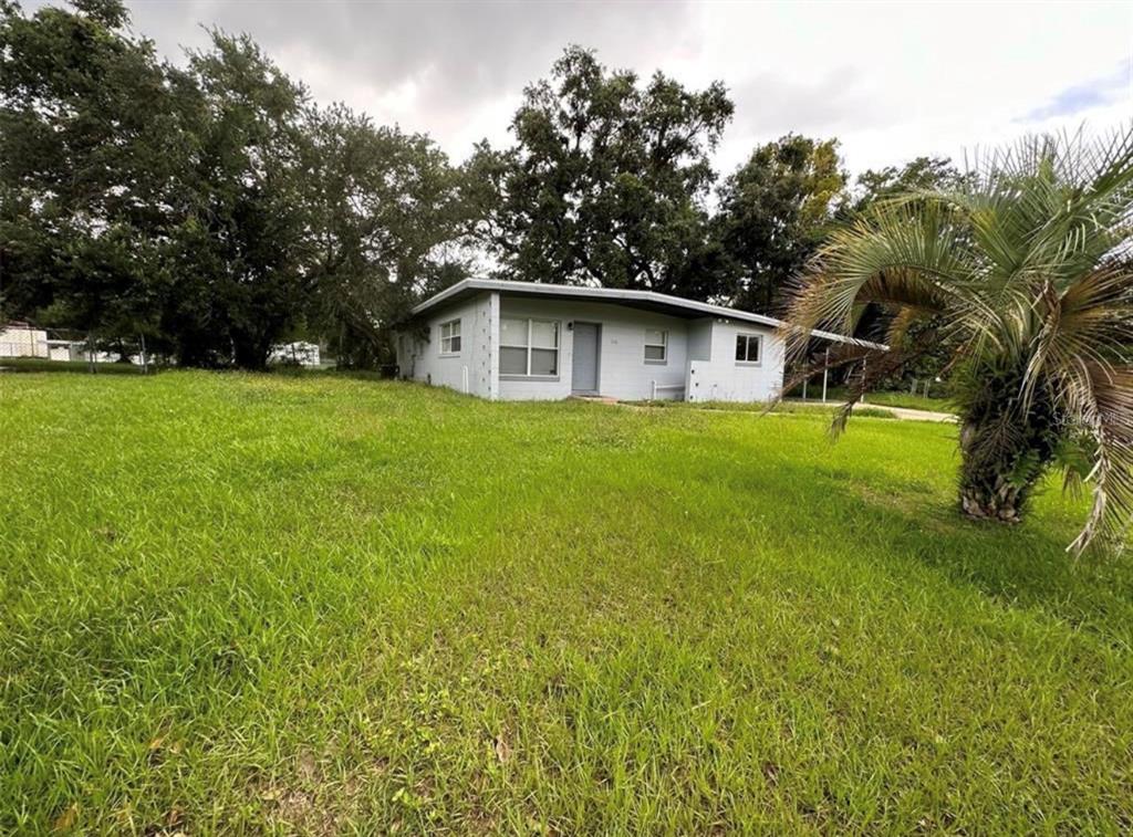 A single-story house with a light gray exterior sits on a large, grassy lot — 116 JUPITER CIRCLE, ORLANDO, FL
