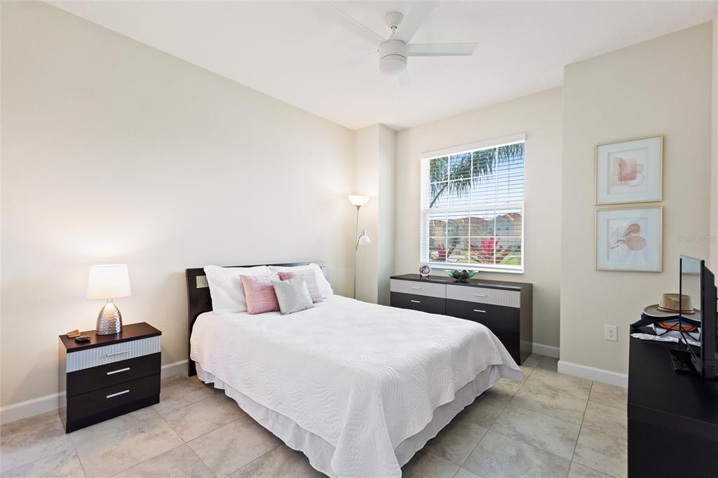 A bedroom with tile floors, a bed, a dresser, and a window with blinds — 8995 ACE LOOP, DAVENPORT, FL