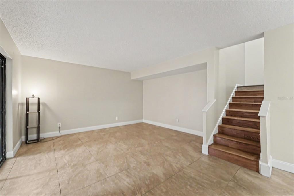A living room features a gray sofa, two yellow armchairs, a coffee table, and stairs — 12310 TOUCHTON DRIVE UNIT 43, TAMPA, FL