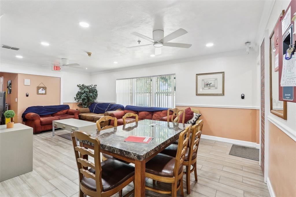 A dining area with a marble table and chairs sits before a living room with sofas — 201 ROSEFIELD AVENUE, LEESBURG, FL
