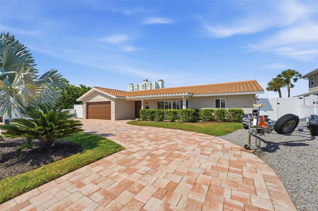 A single-story house with a brown garage door, tiled roof, and a paved driveway — 6414 2ND PALM POINT, ST PETE BEACH, FL