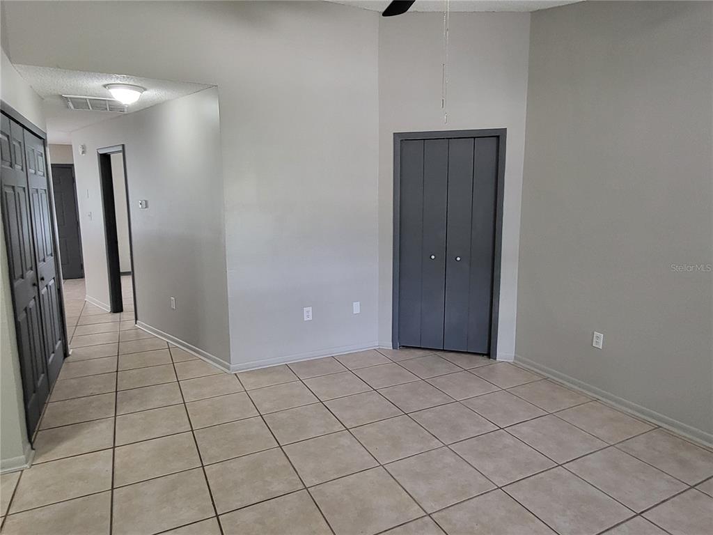 An interior room features light-colored floor tiles, gray walls, and dark gray closet doors — 787 LINCOLN PARKWAY, OVIEDO, FL
