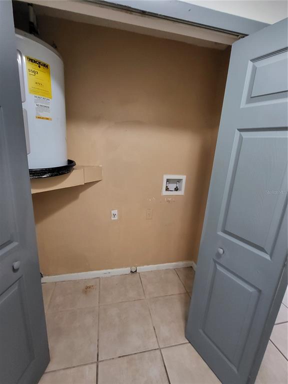 A laundry closet with a water heater, plumbing hookups, and tiled flooring — 787 LINCOLN PARKWAY, OVIEDO, FL