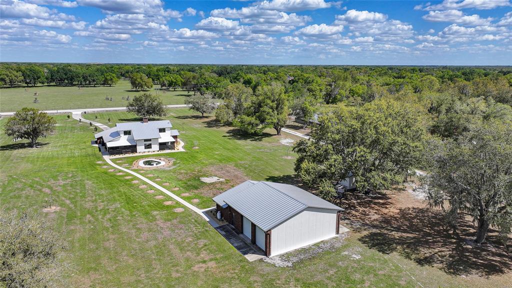 An aerial view shows a house and a detached garage on a large grassy lot — 3049 SW COUNTY ROAD 769, ARCADIA, FL