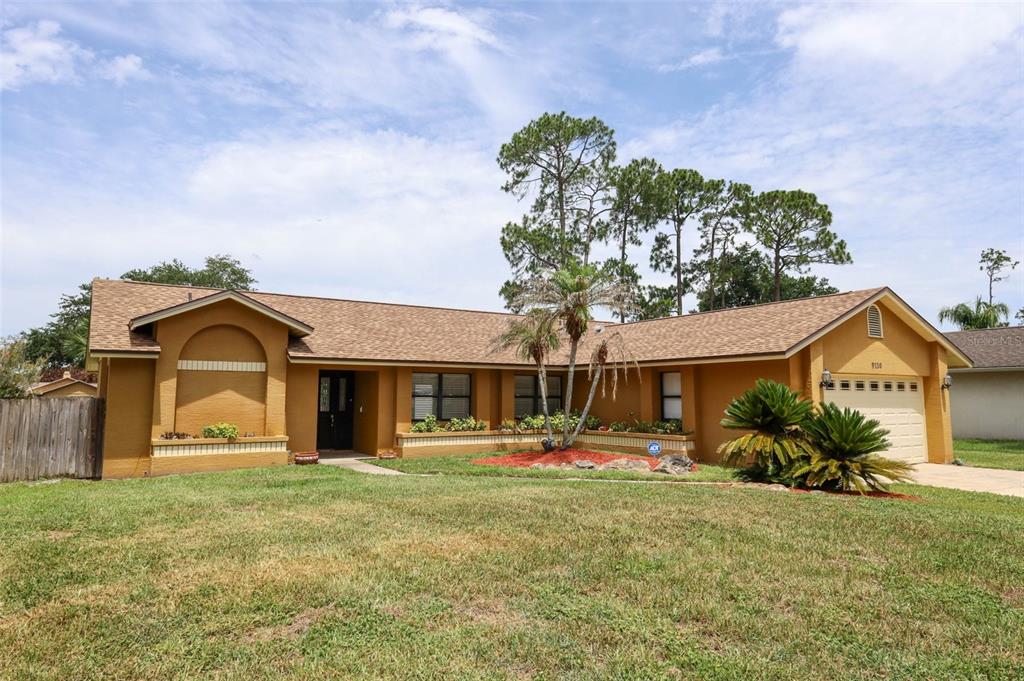 A single-story house with a tan exterior, brown roof, and a two-car garage — 9110 PALM TREE DRIVE, WINDERMERE, FL