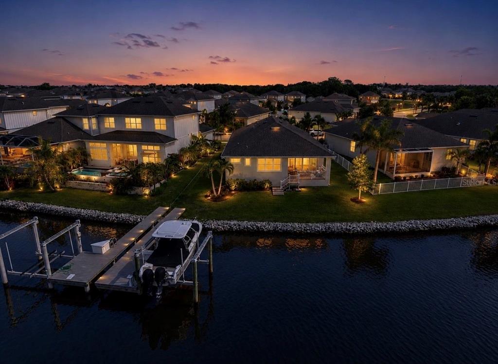 An aerial view of waterfront houses at sunset with a private dock and boat — 5347 WISHING ARCH DRIVE, APOLLO BEACH, FL