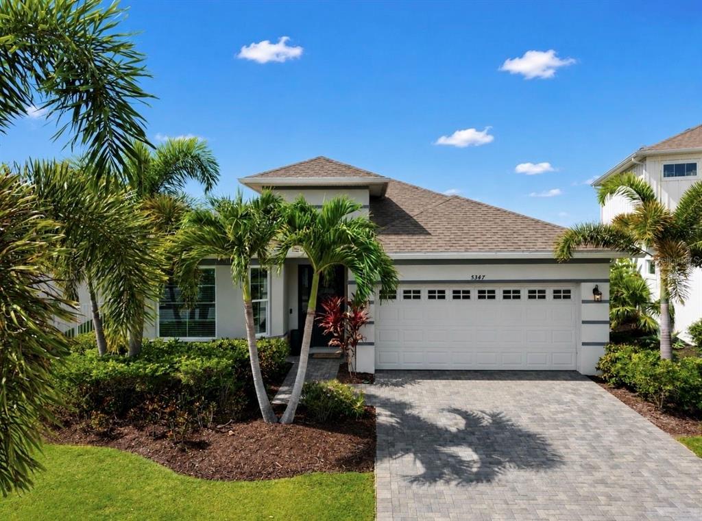 A single-story house with a white exterior, a two-car garage, and palm trees in front — 5347 WISHING ARCH DRIVE, APOLLO BEACH, FL