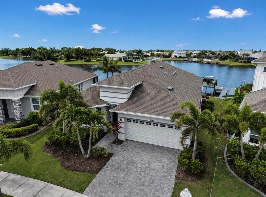 An aerial view of a single-story house with a paved driveway and a waterfront backyard — 5347 WISHING ARCH DRIVE, APOLLO BEACH, FL