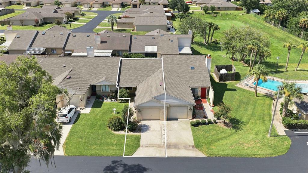 An aerial view shows a single-story attached townhouse with a garage and a driveway — 5033 SE 109TH PLACE, BELLEVIEW, FL