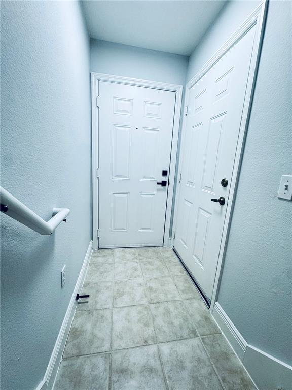 An entryway features two white paneled doors, light-colored tile flooring, and a white handrail — 233 SOUTHERN PECAN CIRCLE UNIT 101, WINTER GARDEN, FL
