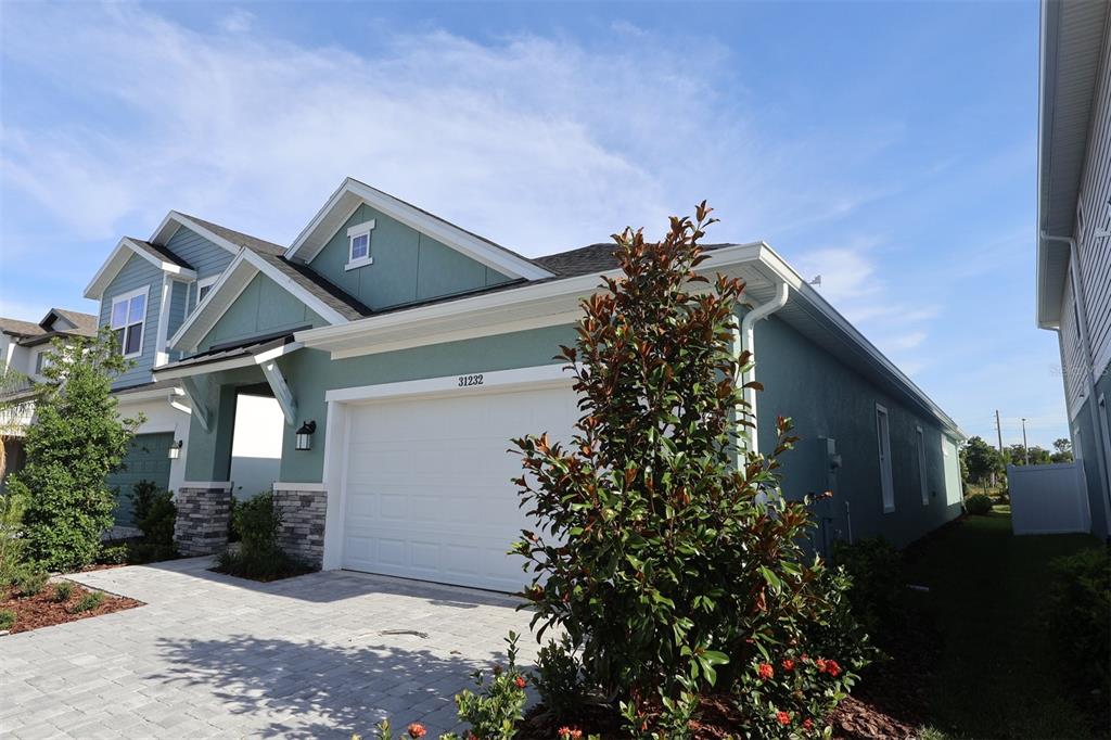 A modern kitchen features white cabinets, a central island with bar stools, and light flooring — 31232 PENDLETON LANDING CIRCLE, WESLEY CHAPEL, FL