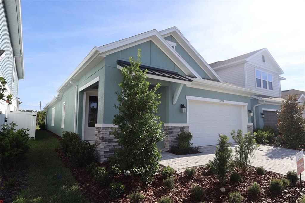 A modern kitchen features white upper cabinets, a dark island with a quartz countertop, and flooring — 31232 PENDLETON LANDING CIRCLE, WESLEY CHAPEL, FL