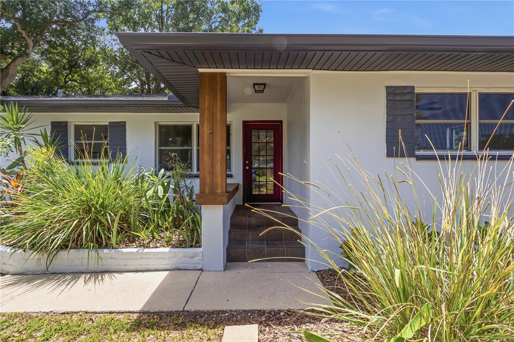 The exterior of a white house features a red front door and a wooden post — 10 S ORION AVENUE, CLEARWATER, FL